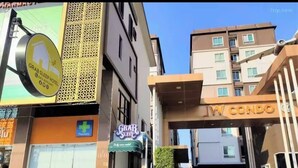 A hotel entrance with a sign for 'Grab Sleep Hotel' and 'Pharmacy' visible.