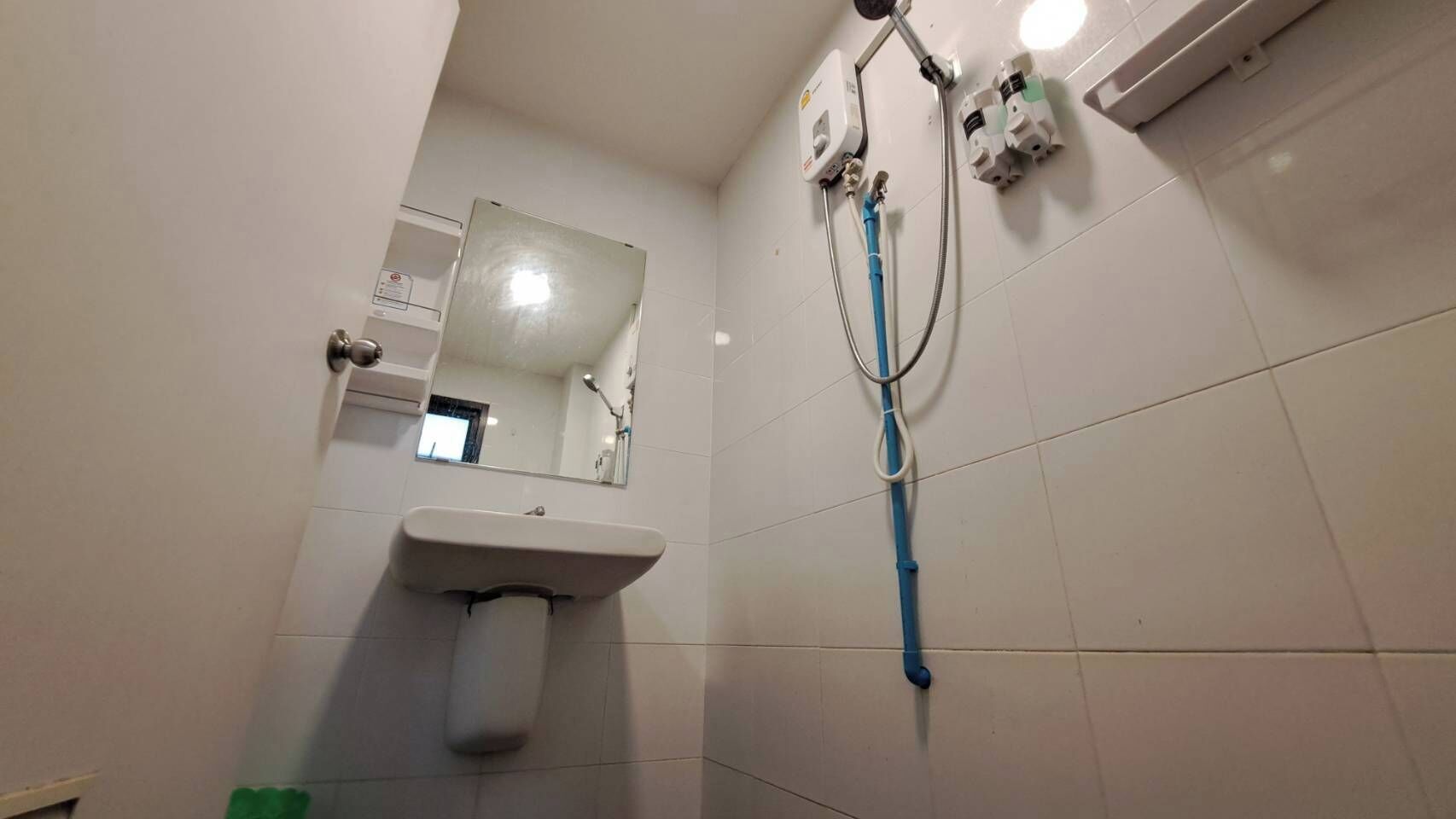 Ein Badezimmer mit Waschbecken, Spiegel und Duscharmaturen.