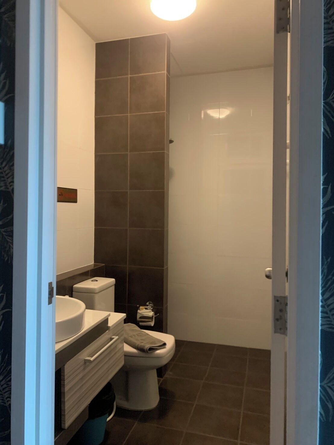 A bathroom with a toilet, sink, and a shower area.