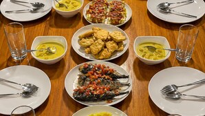 Un tavolo apparecchiato con diversi piatti e posate, disposti in modo simmetrico.