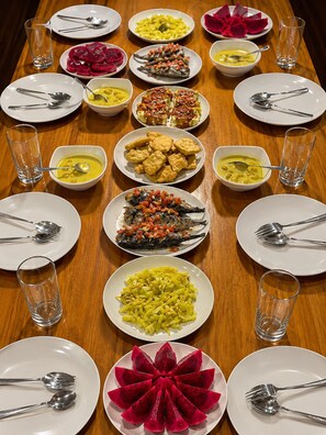 A table set with various dishes and cutlery, arranged in a symmetrical pattern. - Nur Homestay Mini Resto and Souvenir (Papan Island)