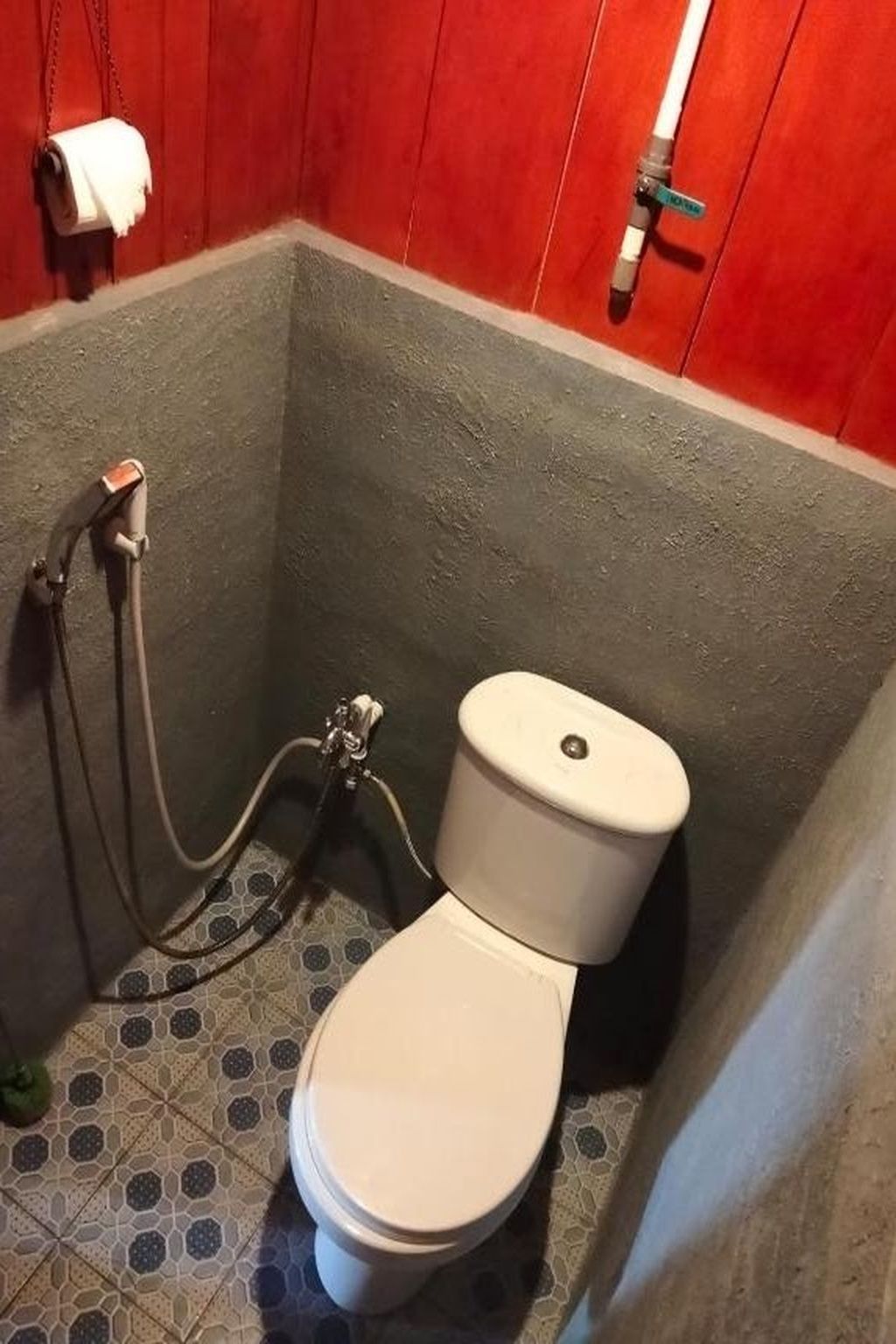 Un baño con inodoro, ducha y toallero.