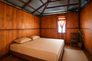 A wooden room with a bed, a window with curtains, a chair, and a potted plant. - Nur Homestay Mini Resto and Souvenir (Papan Island)