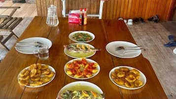 A wooden dining table with various dishes and utensils.