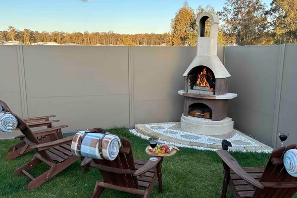 Cozy outdoor fireplace with chairs—perfect for relaxing by the fire.