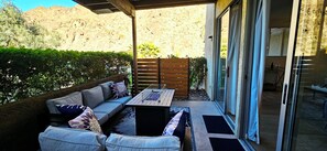 Eine Terrasse im Freien mit einer Couch, einem Tisch und Blick auf eine Berglandschaft.