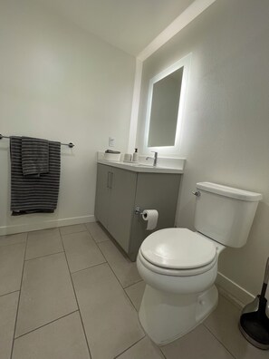Een haardroger, handdoeken, zeep, toiletpapier