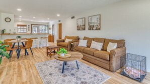 Ein Wohnzimmer mit Sofa, Couchtisch und Essbereich mit Stühlen.