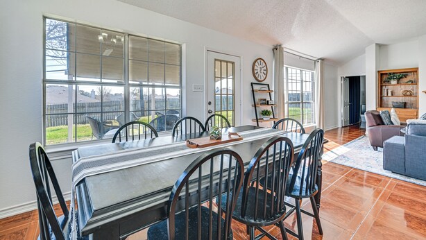 Un comedor amplio con una mesa larga, sillas y vistas al exterior.