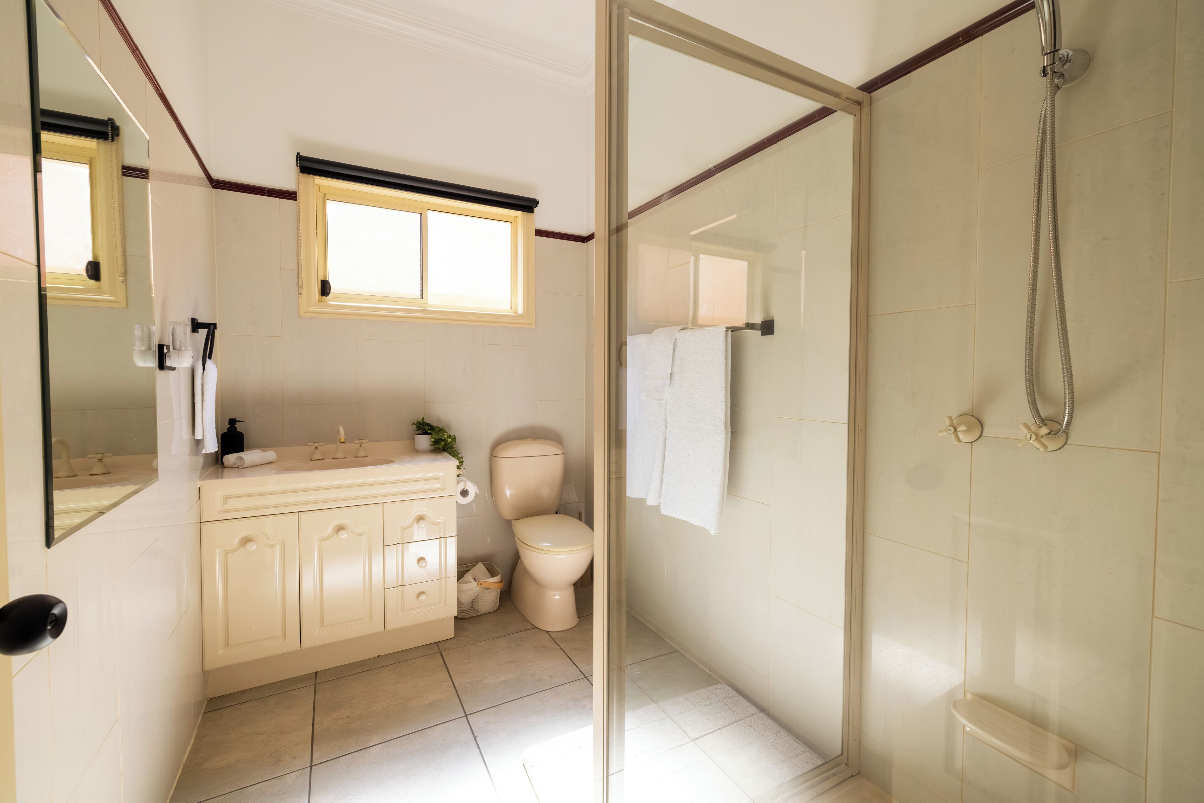 Ein Badezimmer mit Toilette, Waschbecken, Spiegel und Dusche.