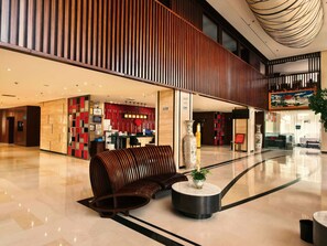 A modern lobby with a reception desk, seating area, and a large vase. - Moonlight International Hotel - Shangri-La Dukezong Ancient City (Deqin)