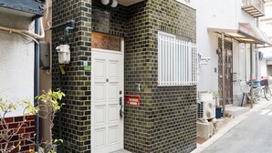 A residential building with a white door, a mailbox, and a small air conditioning unit on the side. - Recommended for USJ, Osaka Sight Seeing,Newly Reno! 5min walk to station. 2bed (Osaka)