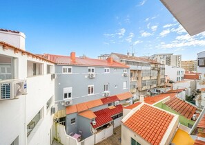 Un quartier résidentiel composé de plusieurs immeubles, dont certains sont surmontés de toits à tuiles rouges et dotés de balcons.