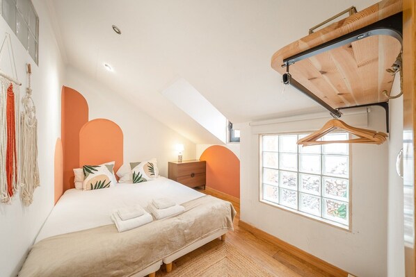 Une chambre à coucher avec un lit, une table de chevet et une fenêtre donnant sur un beau paysage.