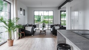 Una sala de estar moderna con un ventanal grande, un comedor y una cocina.