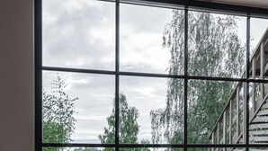 Una habitación con un ventanal grande, una mesa y sillas.