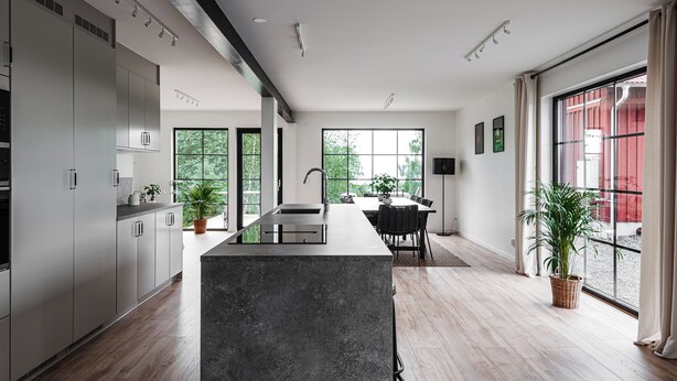 Una cocina moderna con una isla central, ventanas amplias y un comedor con vistas.