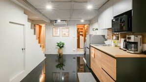 A modern kitchen with a stainless steel refrigerator, a coffee maker, and a microwave. - Industrial Loft Sukhumvit 3-Bedroom Designer House - 2 Min to BTS Bang Chak (Krung Thep Maha Nakhon)