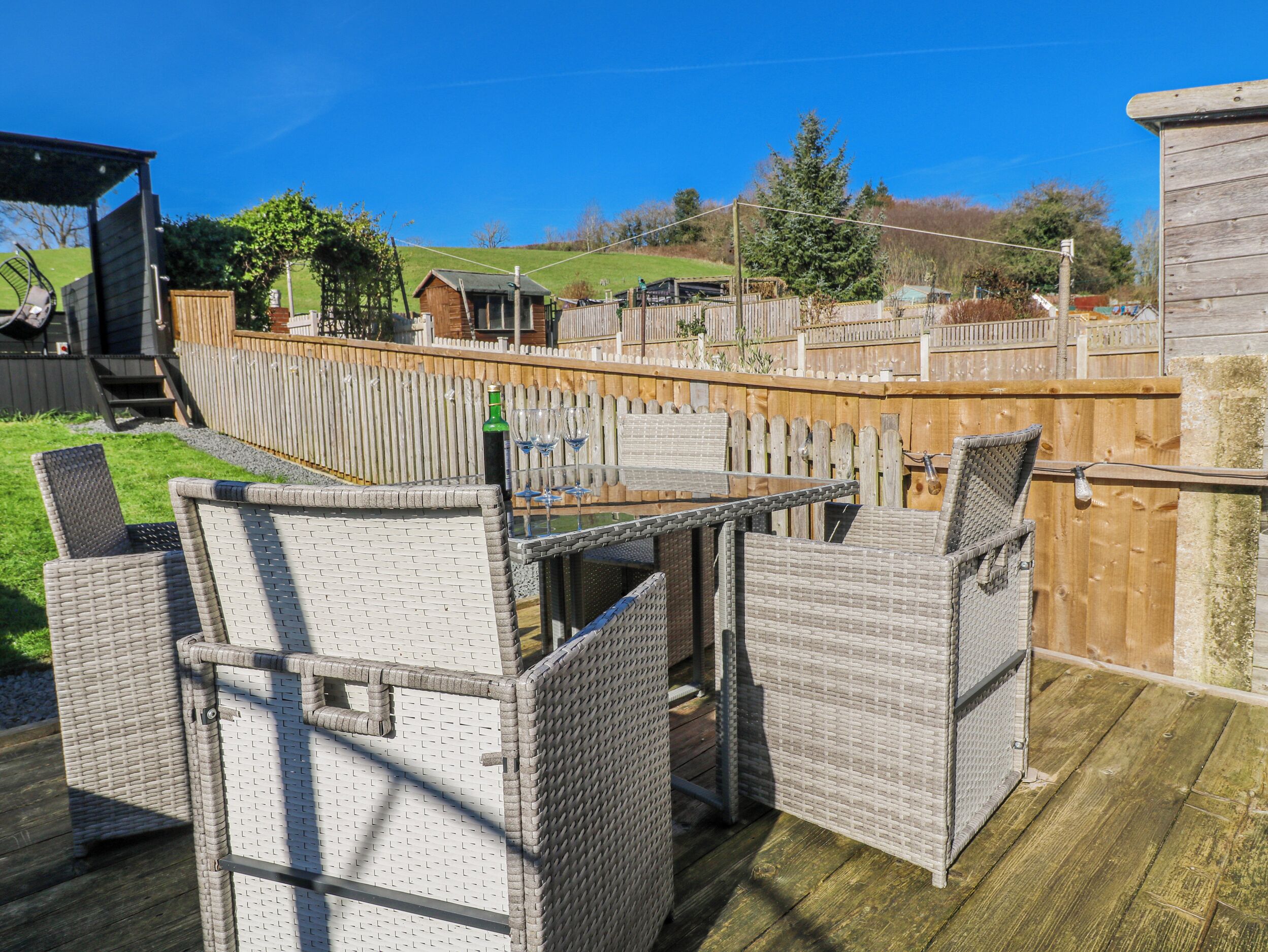 A patio with wicker furniture, a table, and chairs.
