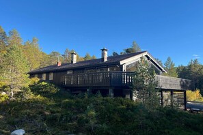 Eine Holzhütte mit Balkon, umgeben von Bäumen.