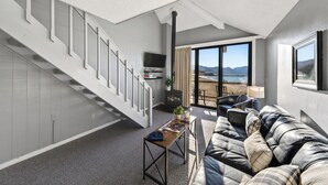 Un salon moderne avec un escalier, un canapé, une table basse et une vue sur la plage.