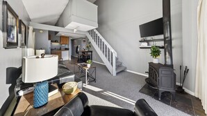 Un salon moderne doté d’une cheminée, d’un coin repas et d’un escalier menant à un étage supérieur.