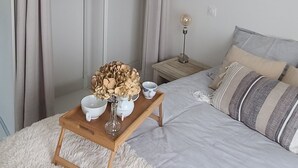 Ein Schlafzimmer mit einem Bett, einem Nachttisch, einer Pendelleuchte und einem Kleiderschrank.