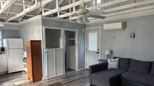 A modern kitchen with a refrigerator, wooden cabinet, and a ceiling fan. - Cozy 2-bedroom cabin in peaceful Tow with AC (Tow)