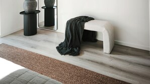 A minimalist room with a large mirror, a bench, and two vases on a pedestal. - Vila Karup Modern Scandinavian Holiday Home (Båstad)