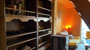 Een knus interieur met houten planken, een bed en een open haard.