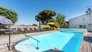 A swimming pool with a wooden deck, lounge chairs, and umbrellas. - Le Parasol (Ars-en-Ré)