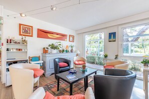 A modern living room with a sofa, armchairs, a coffee table, and a bookshelf. - Le Parasol (Ars-en-Ré)