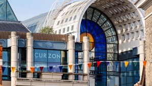 Ein modernes Gebäude mit einer geschwungenen Glasfassade, auf der der Name 'CURZON' sichtbar ist.
