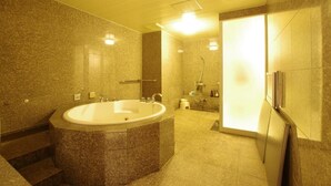 A bathroom with a large freestanding bathtub, a shower area, and a toilet.