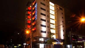A multi-story hotel with a prominent sign, balconies, and a well-lit facade.