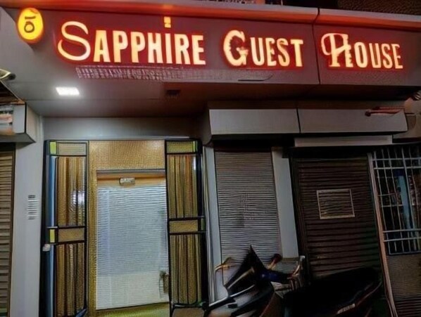 A hotel entrance with a neon sign reading 'Sapphire Guest House.' - sapphire guest house (Kolkata)