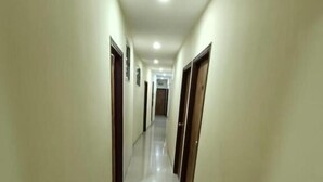 A long, narrow hallway with doors on both sides, leading to a room at the end. - sapphire guest house (Kolkata)