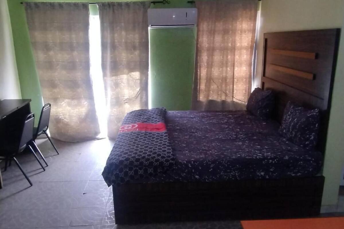 A room with a bed, a desk, and a chair.