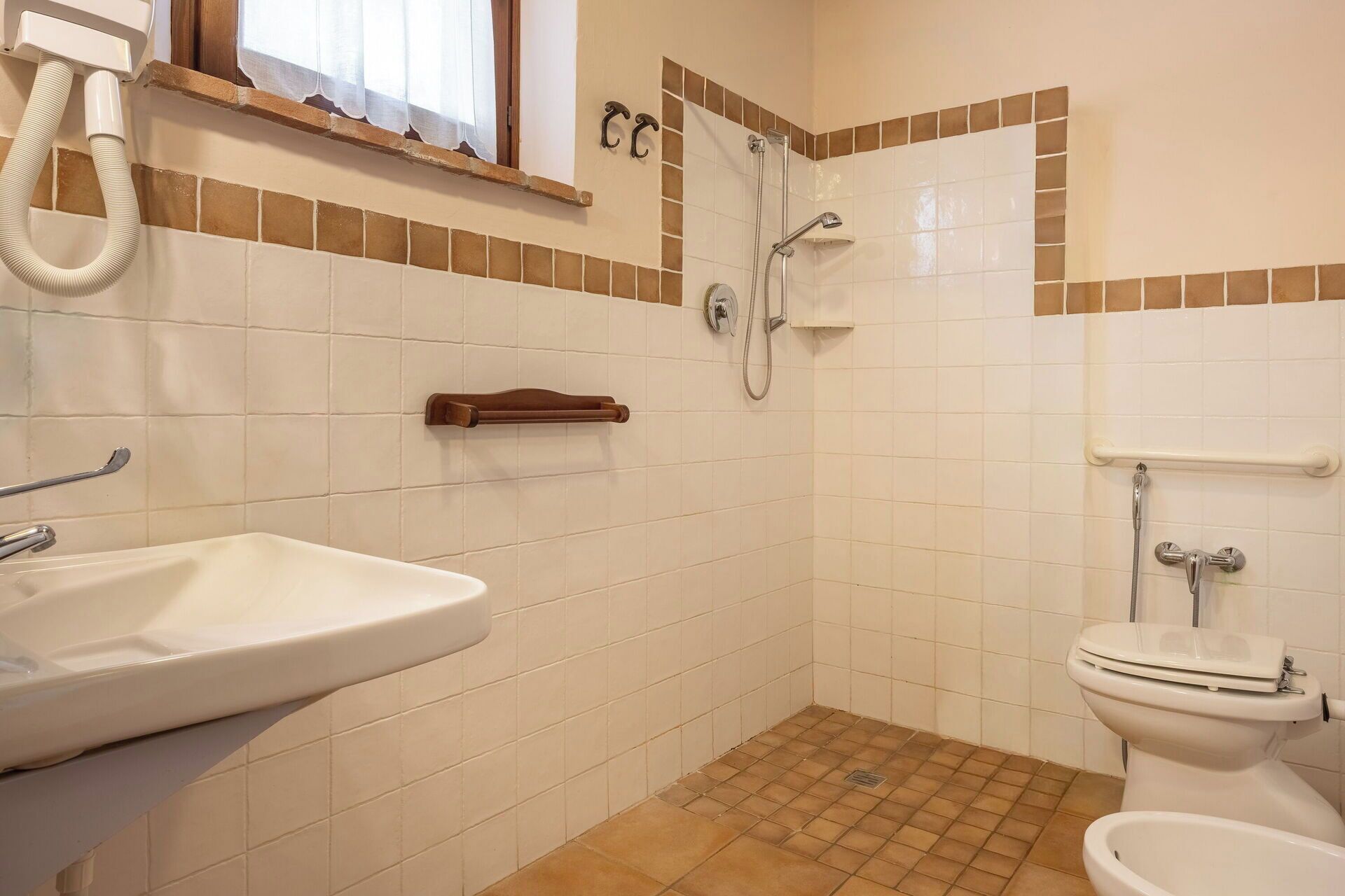A bathroom with a sink, toilet, shower, and a towel rack.