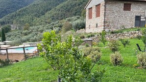 A stone building with a pool, surrounded by lush greenery and hills. - Borgo Antico, Pool - Nido (Barberino Di Mugello)