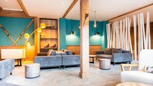 A modern lobby with grey sofas, wooden accents, and pendant lighting.