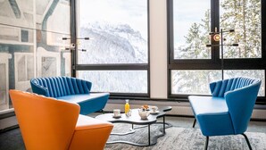 A modern room with large windows, two blue chairs, a small table with breakfast items, and a radiator. - Apartment for 4 person, Flaine (Flaine)