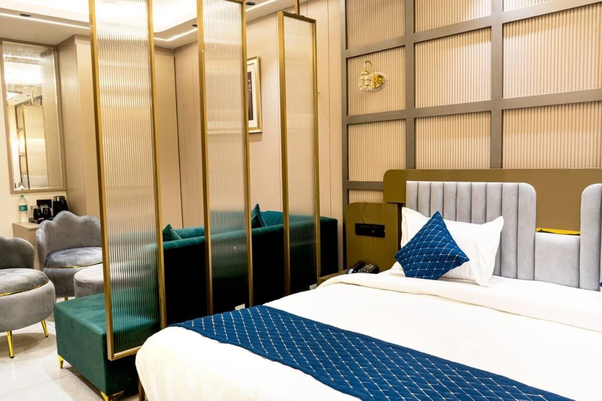 Ein Hotelzimmer mit Bett, Schreibtisch, Stuhl und einem dekorativen Paravan.