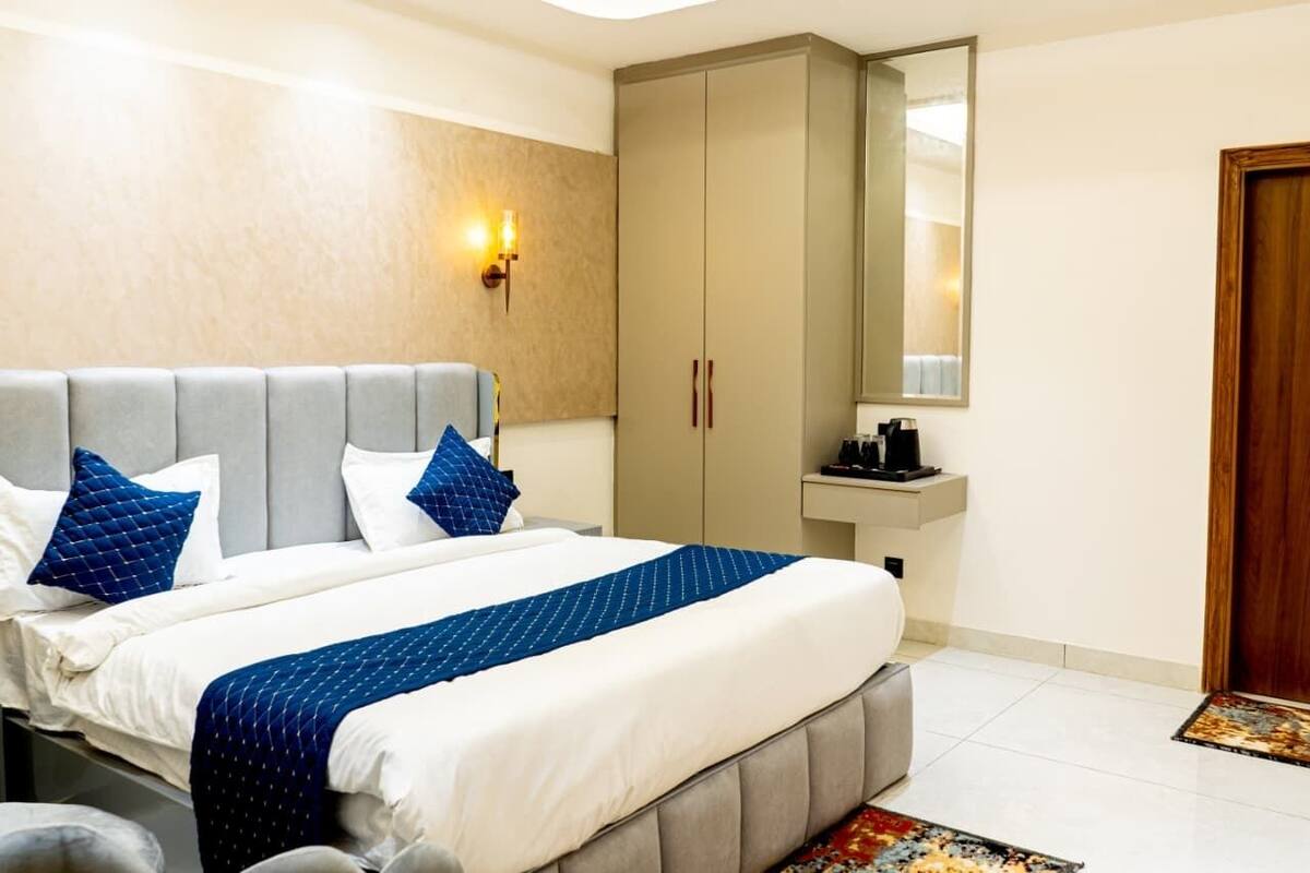 Ein Hotelzimmer mit Bett, Schrank, Spiegel, Waschbecken und Tür.