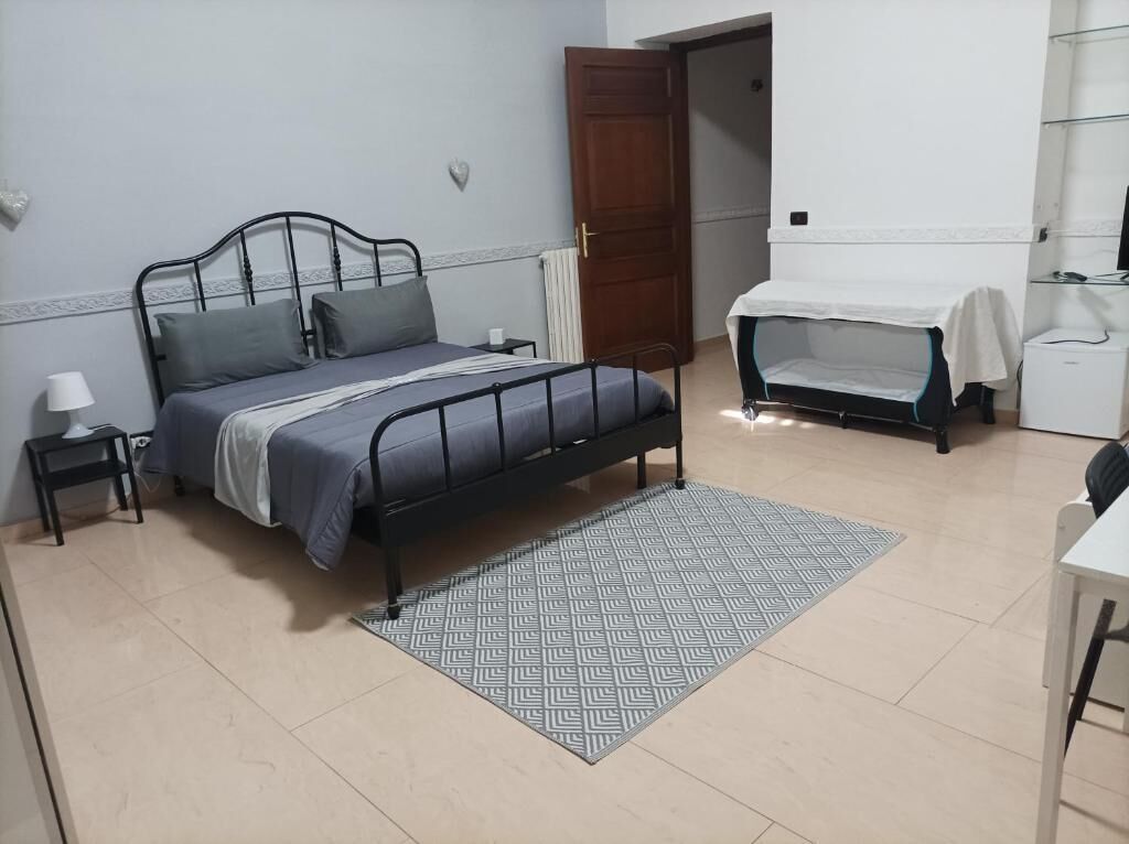 Une chambre à coucher comprenant un lit, une table de chevet, une lampe et un petit bureau avec une chaise.