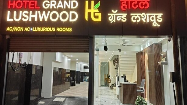 A hotel entrance with a sign reading 'HOTEL GRAND LUSHWOOD' and 'AC/NON AC LUXURIOUS ROOMS'. - Hotel Grand Lushwood (Chhatrapati Sambhajinagar)