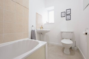 Ein Badezimmer mit Badewanne, Toilette, Waschbecken und Handtuchhalter.