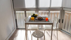 A dining area with a table, chairs, and a view through a window. - Beautiful Apartment by the sea in Almeria (Almeria)