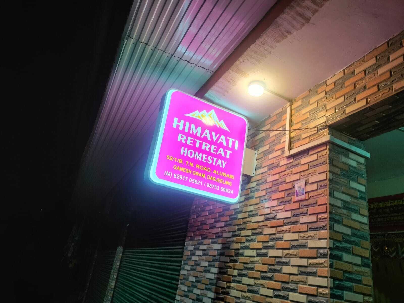 A neon sign for 'HIMAYATI RETREAT HOMESTAY' with contact information.