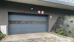 A closed garage door with a sign indicating a 2-meter height limit and LPG storage. - Comfortable Apartment, SPA Zone, Dziwnow (Dziwnów)
